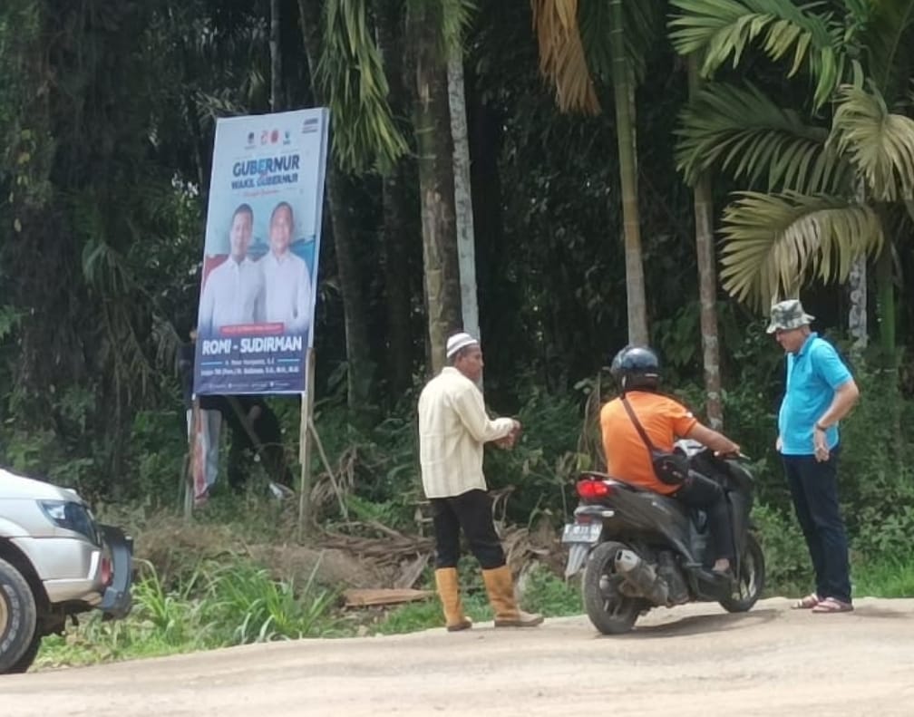 Oknum Lurah (baju biru) yang nekat pasang baliho RH. Foto : ist